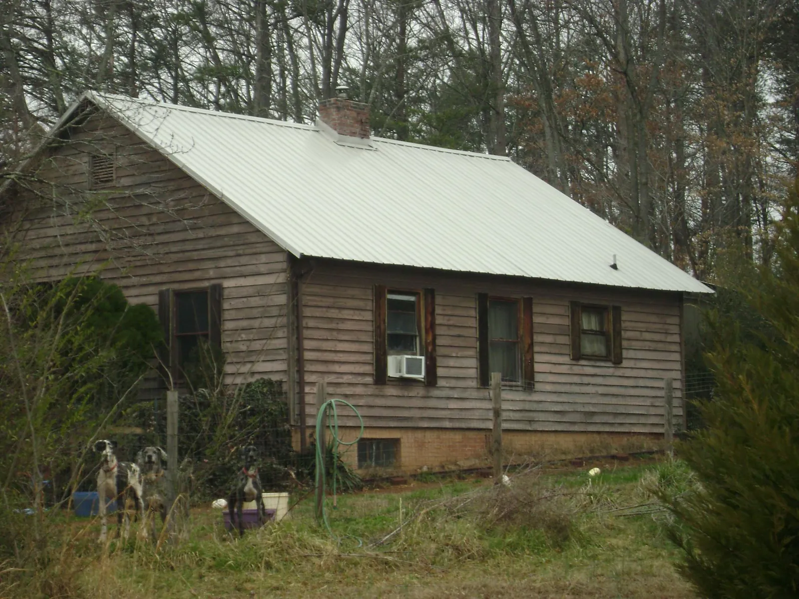 White metal roof on an old wood sided farmhouse, from a Metal Roof Installation job in Grandy